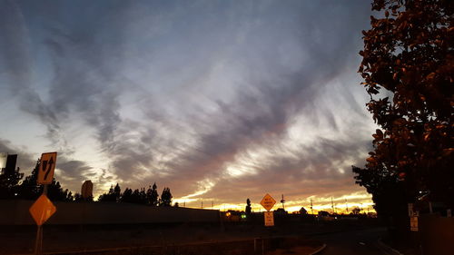 Silhouette built structures against cloudy sky