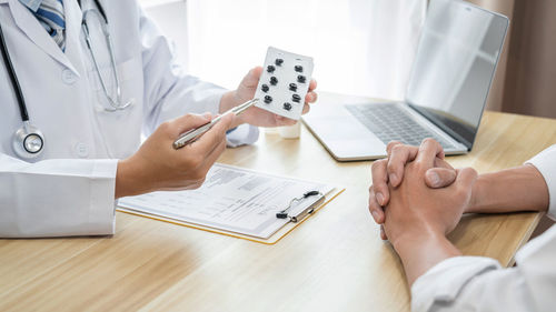 Midsection of doctor working on table