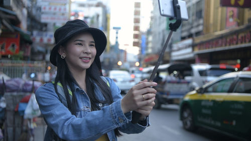 Young woman standing on street in city