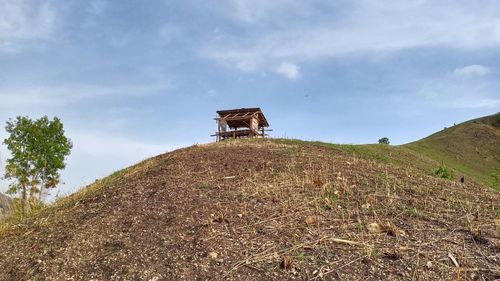 Low angle view of traditional windmill on field against sky