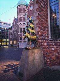 Statue against building in city