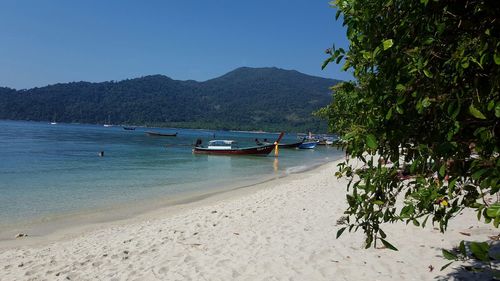 Boats in sea with mountain in background