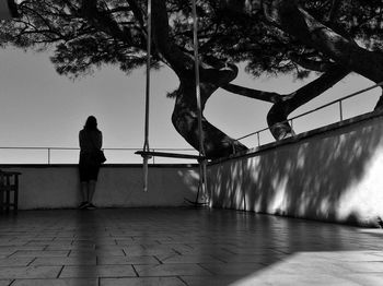 Rear view of man walking on footpath in city