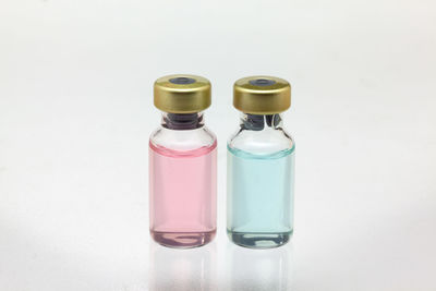 High angle view of bottles on table against white background