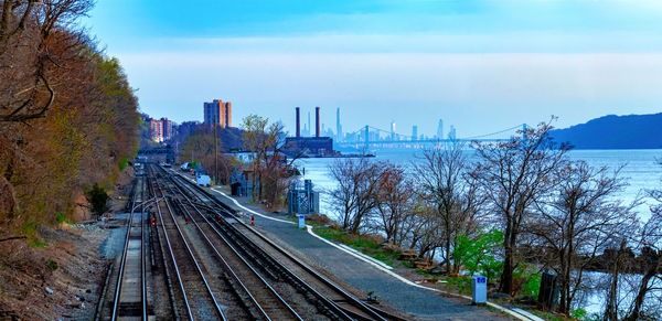 Railroad tracks in city against sky