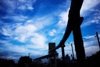 Low angle view of silhouette trees against blue sky