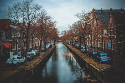 Canal amidst buildings in city against sky