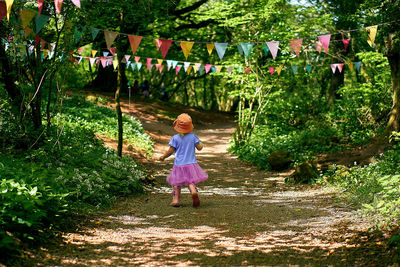 Full length of woman walking on footpath amidst trees