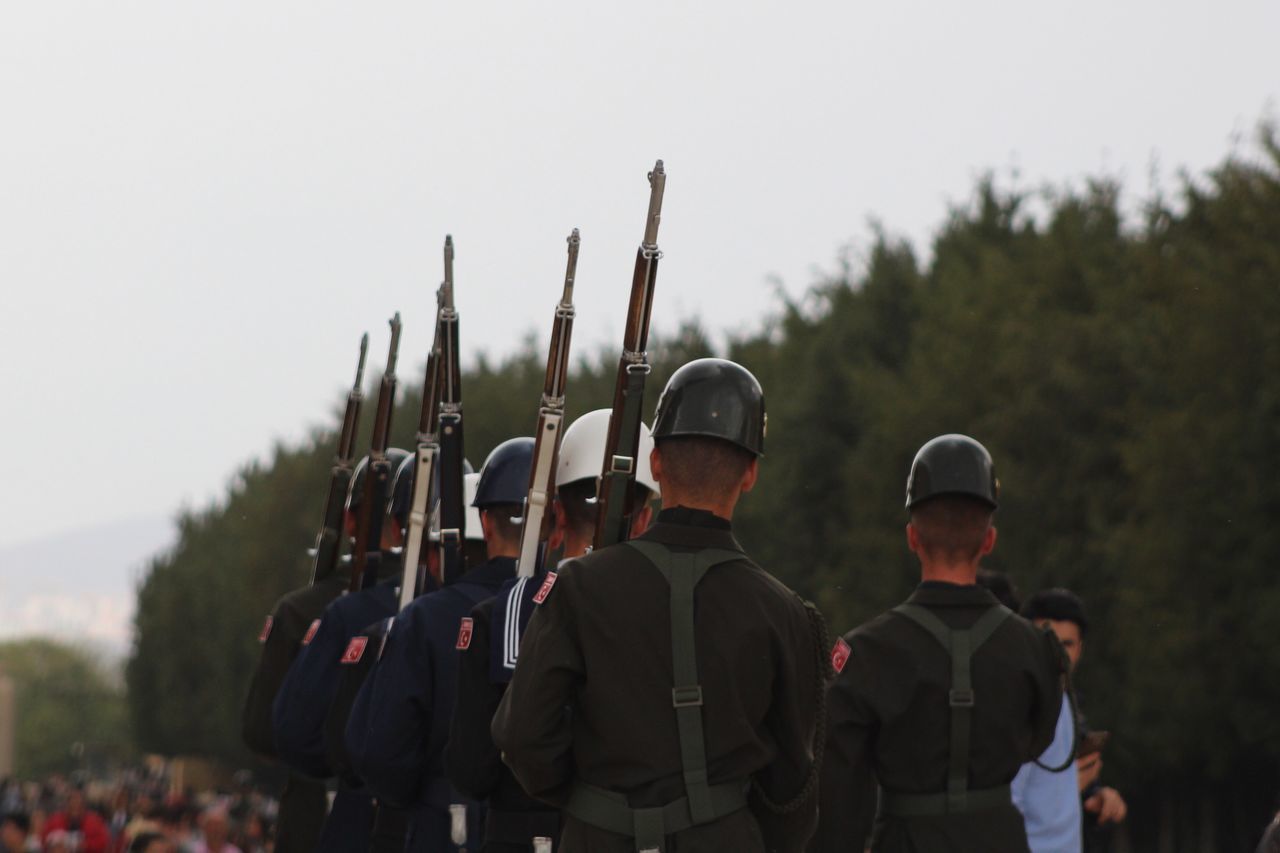 real people, military uniform, uniform, men, protection, army soldier, weapon, rear view, helmet, army helmet, protective workwear, large group of people, army, military, standing, day, responsibility, outdoors, clear sky, headwear, camouflage clothing, riot, people, adult