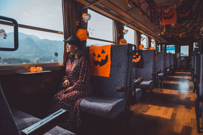 Woman looking through window while sitting in decorated train