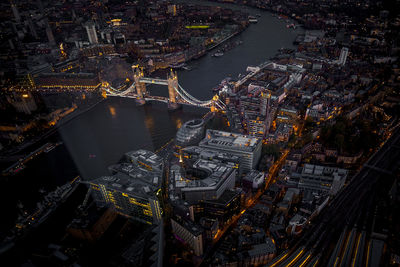 High angle view of illuminated city by river at night