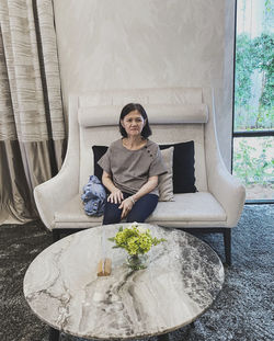 Portrait of young woman sitting on sofa