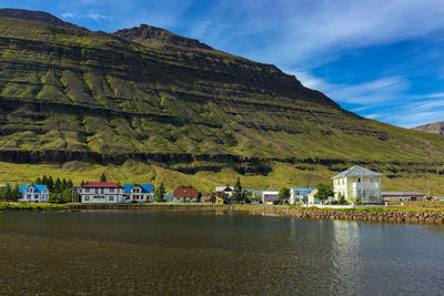 Scenic view of lake by buildings against sky