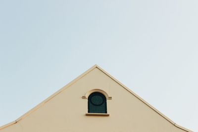 Low angle view of clock on building against clear sky