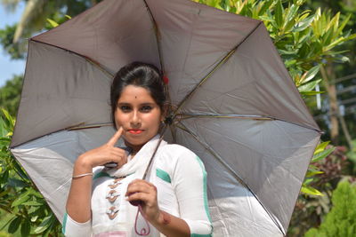 Portrait of young woman holding umbrella