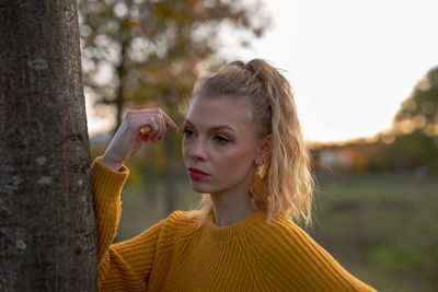 Portrait of young woman against plants