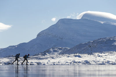 People skiing on frozen lake