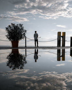 Rear view of woman standing on pier