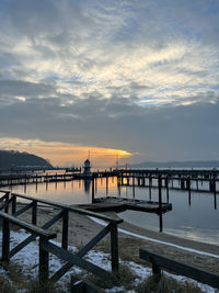 Pier over sea against sky during sunset