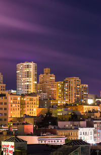 Illuminated cityscape against sky at night