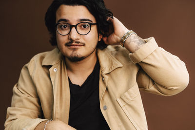 Portrait of man with hand in hair at studio