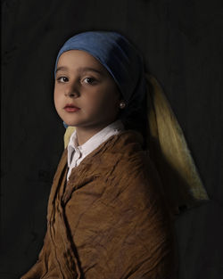 Portrait of woman standing against wall.  girl with a pearl earring
painting by johannes vermeer
