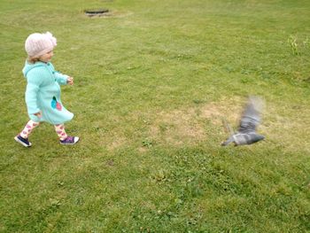 Side view of boy playing on grass