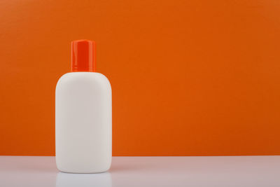 Close-up of bottle against orange background