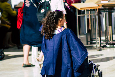 Rear view of women walking on street in city