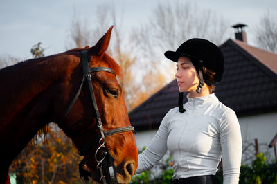 Side view of young woman standing against sky