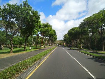 Empty road along trees