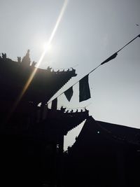 Low angle view of silhouette cranes against sky