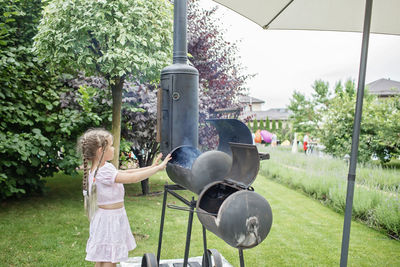 Rear view of woman standing in yard