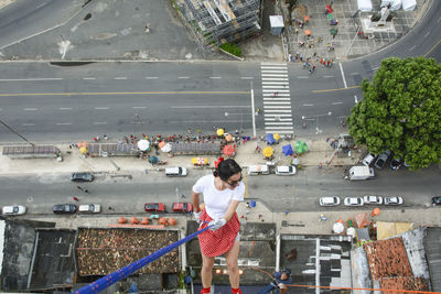 Caucasian woman wearing hero costume descending a tall building in rappel. salvador bahia brazil.