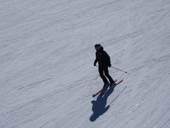 Side view of man skiing on snow covered field