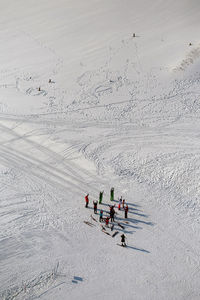 High angle view of excited hikers standing with arms raised on snow