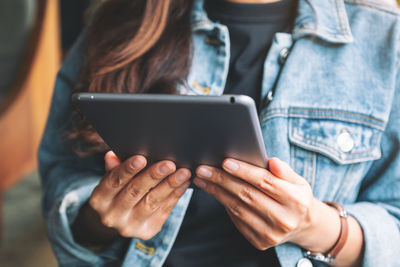 Midsection of man using mobile phone