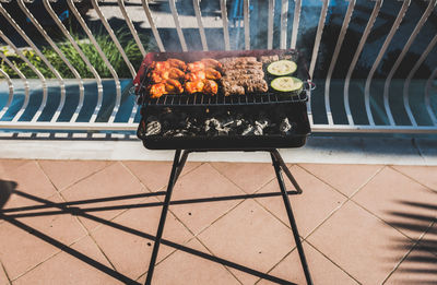 High angle view of meat on barbecue grill at balcony