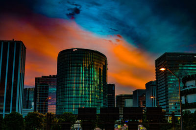 Low angle view of modern buildings against sky at sunset