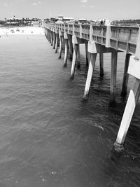 Wooden posts on beach against sky