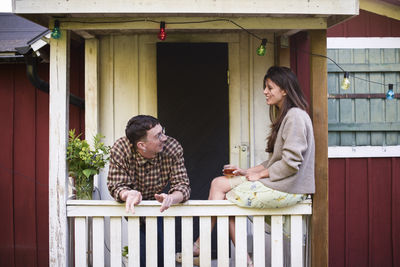 Side view of young woman looking through window