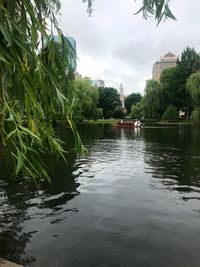 Scenic view of lake against sky in city