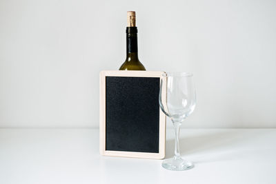 Bottle of wine, glass and empty sign mockup. bottle of wine with empty glass and blackboard mockup