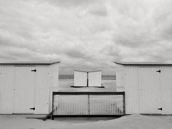 Beach huts against cloudy sky