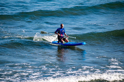 Full length of man rowing boat in sea