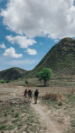Rear view of people walking on mountain road