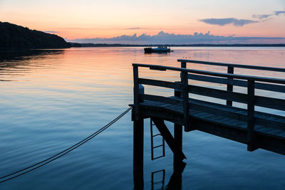 Pier over sea against sky during sunset