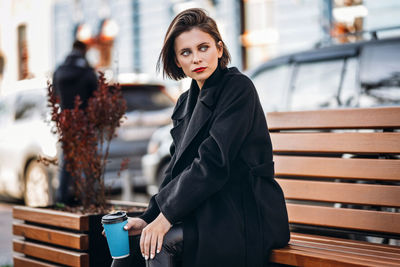 Portrait of young woman standing on seat