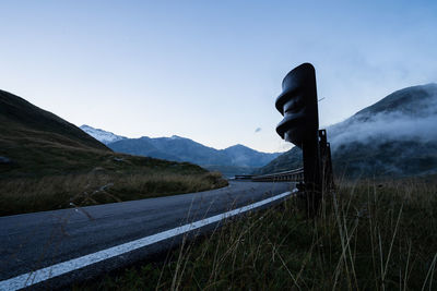 Road amidst field against sky