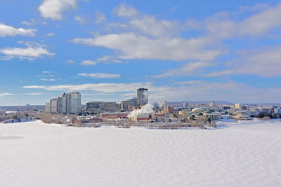 Buildings in city against cloudy sky